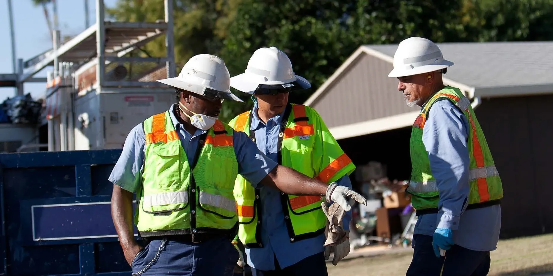 Workers in safety gear at construction site.